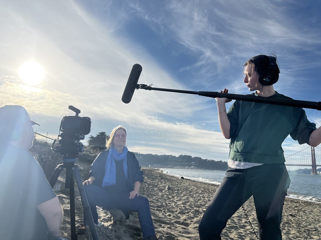 Katia Noyes being filmed by director Daniel Talbott on a San Francisco beach