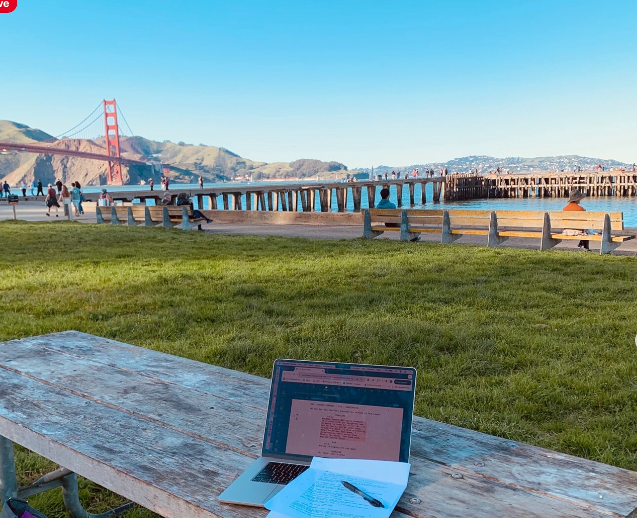 Screenplay pages and a laptop beside the Golden Gate Bridge